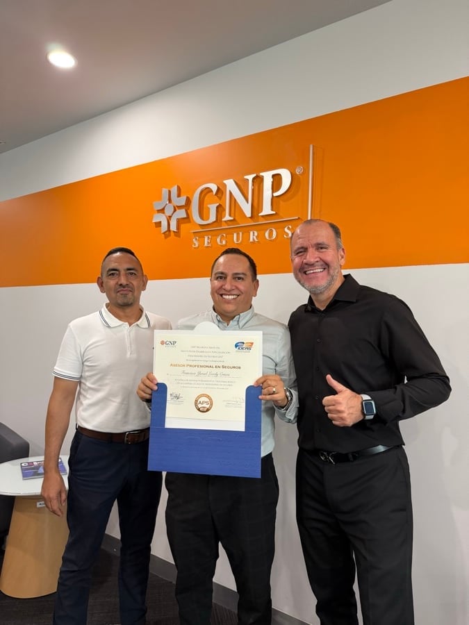 Three men posing in front of an orange CNP Seguros wall, with the center man holding a certificate and giving a thumbs up.